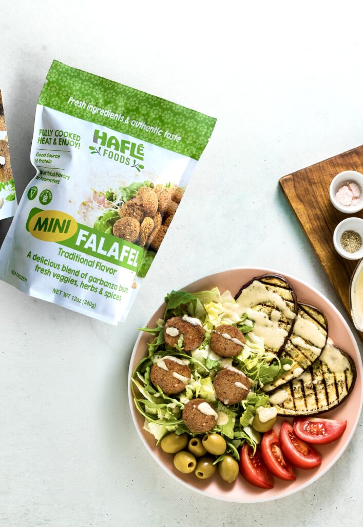 banner of an appetizing dinner or lunch from a salad with tomatoes, grilled eggplants and legume falafel with sesame tahini dressing. Vegan healthy food for the whole family